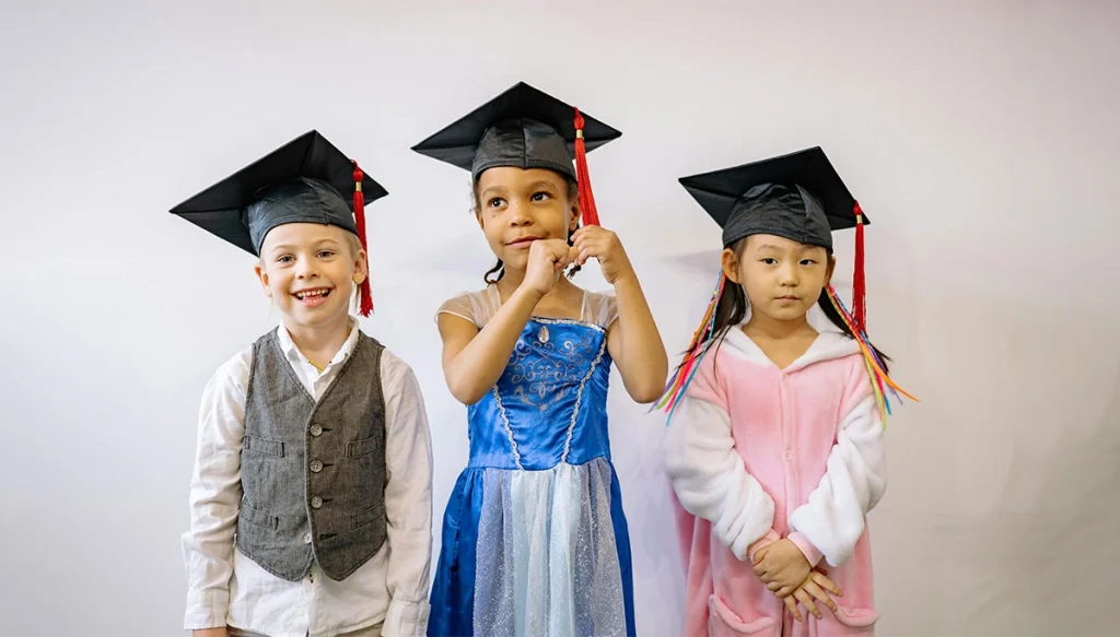 children with graduation hats on smiling