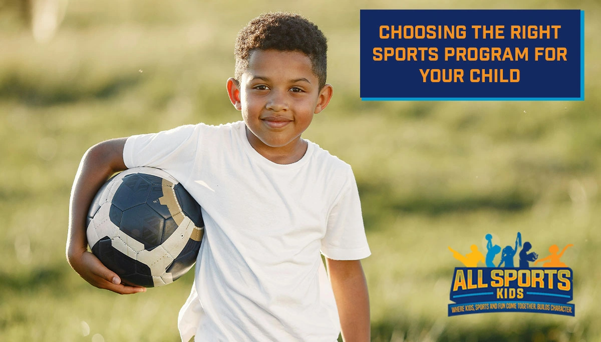 A young boy holding a soccer ball while smaling